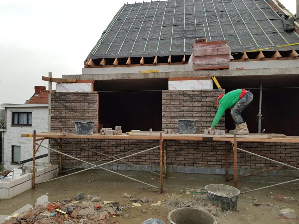 Een werknemer die bezig is met dakwerken voor een woning van B-Invest Group