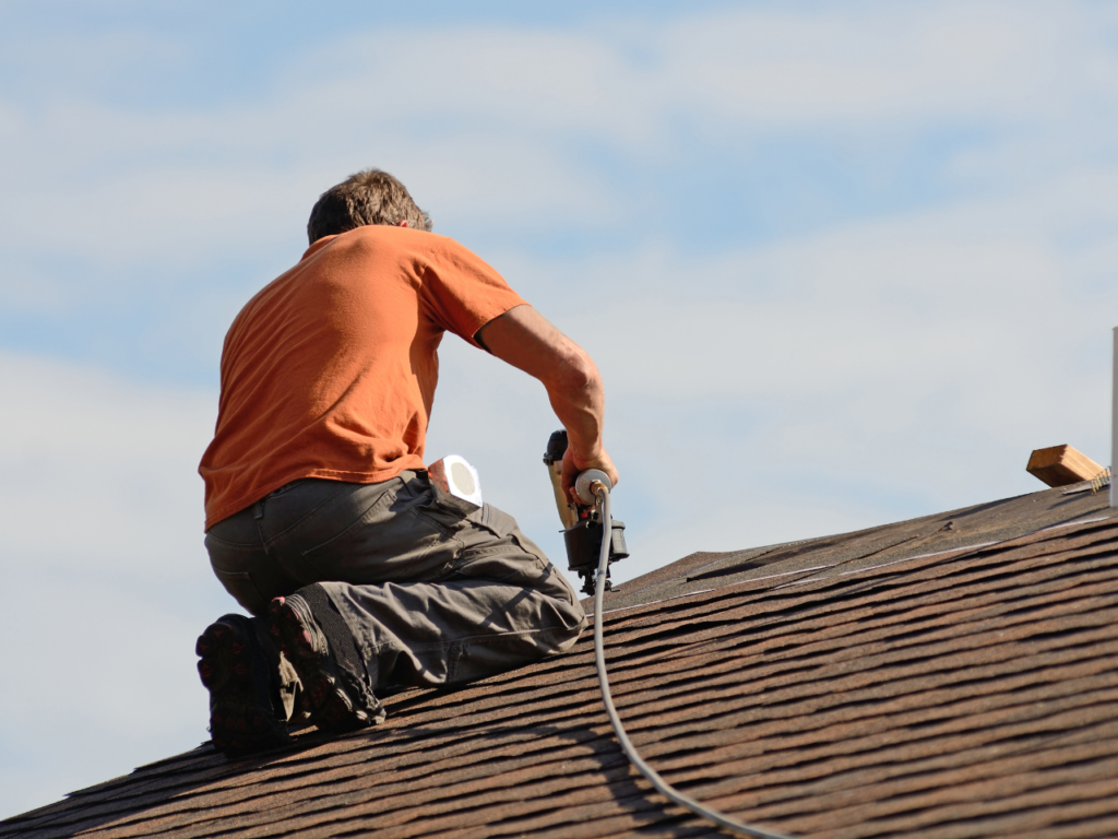Een dakwerker van B-Invest Group die bezig is met dakwerken.